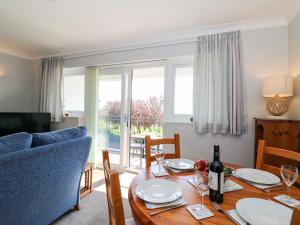 uma sala de jantar com uma mesa e um sofá azul em Lookout em Weymouth