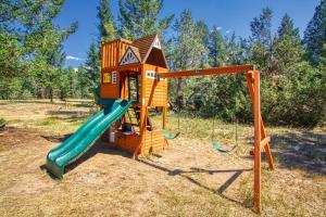 a playground with a slide and a play house at The Raven's Nest Resort & Campground in Fairmont Hot Springs