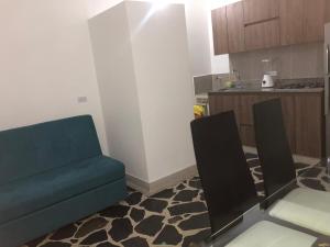 a living room with a blue couch and a kitchen at Apartamento amplio, excelente ubicación 3 alcobas 403 in Medellín