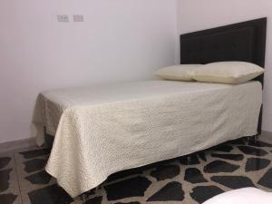 - un lit avec des draps et des oreillers blancs dans l'établissement Apartamento amplio, excelente ubicación 3 alcobas 403, à Medellín
