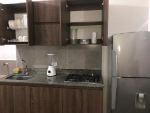 a kitchen with a sink and a refrigerator at Apartamento amplio, excelente ubicación 3 alcobas 403 in Medellín