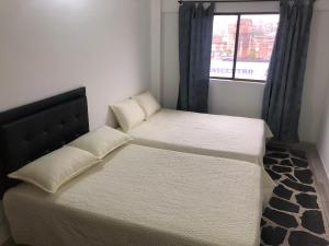 a bedroom with two beds and a window at Apartamento amplio, excelente ubicación 3 alcobas 403 in Medellín