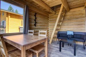 a dining room with a table and chairs in a log cabin at The Raven's Nest Resort & Campground in Fairmont Hot Springs