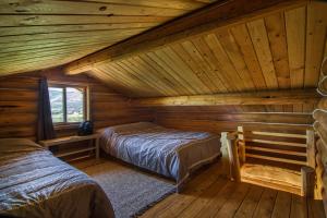 a bedroom with two beds in a log cabin at The Raven's Nest Resort & Campground in Fairmont Hot Springs