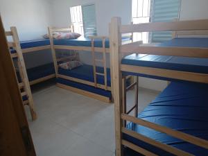 a room with three bunk beds with blue sheets at #Pousada São Paulo SP ótima localização in Sao Paulo