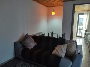 un divano in soggiorno con cuscini di Casa cantinho do aconchego a Campos do Jordão
