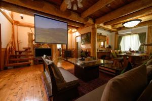 a living room with a large screen in a house at 貸別荘Clover　天城杉のログハウス　伊豆高原 in Ito