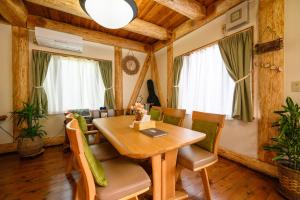 ein Esszimmer mit einem Holztisch und Stühlen in der Unterkunft 貸別荘Clover　天城杉のログハウス　伊豆高原 in Ito