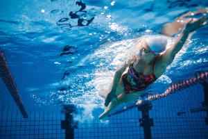 een vrouw zwemt in een zwembad bij A Comfy & Cozy 2BR Apt Near Flemington Races in Melbourne