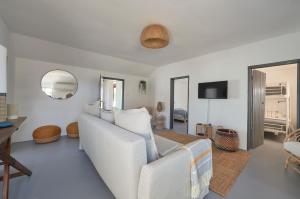 a living room with a white couch and a mirror at Comporta Sandy Villa, By TimeCooler in Comporta