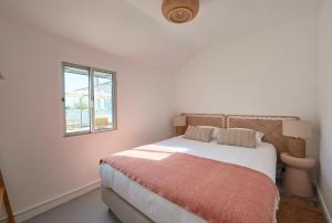 コンポルタにあるComporta Sandy Villa, By TimeCoolerの白いベッドルーム(ベッド1台、窓付)
