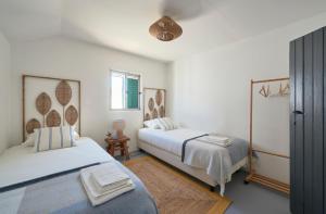 um quarto com 2 camas e uma janela em Comporta Sandy Villa, By TimeCooler em Comporta