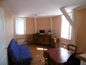 een woonkamer met een tafel en een blauwe stoel bij Appartement Trouville-sur-Mer, 3 pièces, 4 personnes - FR-1-712-18 in Trouville-sur-Mer