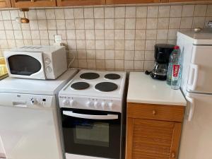 a kitchen with a stove and a microwave at Appartement Trouville-sur-Mer, 3 pièces, 4 personnes - FR-1-712-18 in Trouville-sur-Mer
