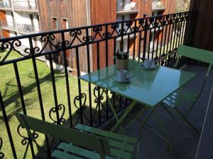 a table and chairs on a balcony with a fence at Appartement Bagnères-de-Luchon, 2 pièces, 4 personnes - FR-1-313-222 in Luchon