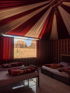 a room with two beds with a view of the desert at Beduin Star Trail Camp in Wadi Rum