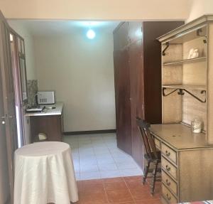 a kitchen with a table and a desk and a table and chair at Apartamento Standard in Cochabamba