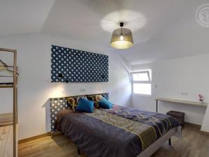 een slaapkamer met een bed met een blauw hoofdeinde bij Gîte Balbigny, 3 pièces, 4 personnes - FR-1-496-282 in Balbigny