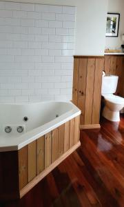 a bathroom with a white tub and a toilet at Tall Trees Eco Retreat - Fern Cottage in Apollo Bay