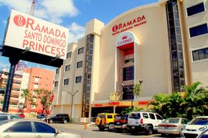 um parque de estacionamento com carros estacionados em frente aos edifícios em Ramada by Wyndham Princess Santo Domingo em Santo Domingo