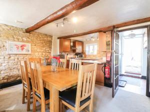 Manor View في أوكهام: مطبخ وغرفة طعام مع طاولة وكراسي خشبية