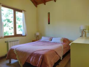 1 dormitorio con cama y ventana en Cabañas El estribo sur Bariloche 3p en San Carlos de Bariloche