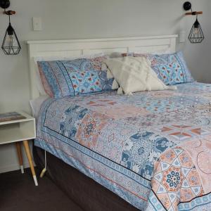 a bedroom with a bed with a blue comforter at Welbourn Accommodation in New Plymouth