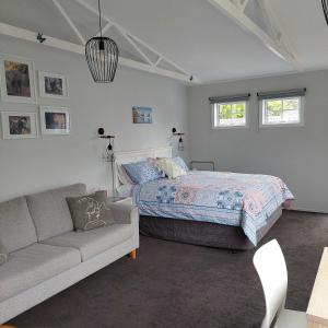 a bedroom with a bed and a couch at Welbourn Accommodation in New Plymouth