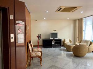 a living room with a tv and a couch and chairs at Wantana Mansion Check in before 8 pm in Hat Yai