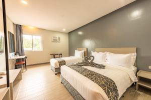 Pokój hotelowy z 2 łóżkami i biurkiem w obiekcie Hotel One w Cebu