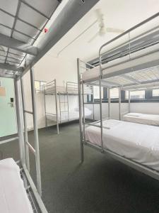 a room with three bunk beds in a building at The Downing Hostel in Sydney