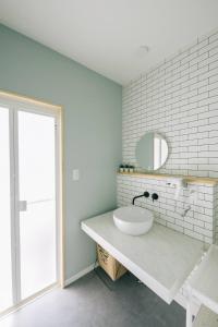 een witte badkamer met een wastafel en een spiegel bij 天草VIVID V2 in Kami Amakusa