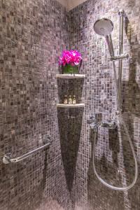 uma casa de banho com um chuveiro com flores cor-de-rosa num cesto em Hotel One Eighteen em Hong Kong