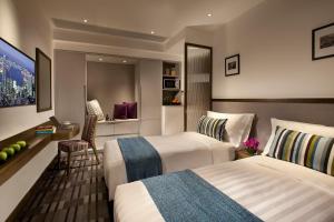 um quarto de hotel com duas camas e uma escrivaninha em Hotel One Eighteen em Hong Kong mais 4 fotografias