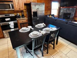 uma cozinha com uma mesa preta com cadeiras e um frigorífico em Heated Pool Hot Tub Game Room Mountain Views em Sevierville