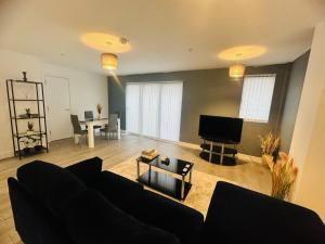 a living room with a couch and a television at Hemel Apartments - Hemel Haven in Hemel Hempstead