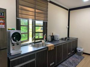 a kitchen with a sink and a counter with a microwave at Teratak Bayu STC in Kuala Terengganu