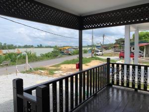 eine Veranda mit Blick auf eine Straße und einen Fluss in der Unterkunft Teratak Bayu STC in Kuala Terengganu