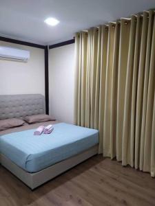ein Schlafzimmer mit einem Bett mit zwei Hausschuhen darauf in der Unterkunft Teratak Bayu STC in Kuala Terengganu