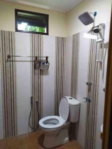 a bathroom with a toilet and a shower with a window at Teratak Bayu STC in Kuala Terengganu