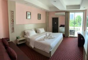 Un dormitorio con una cama grande con dos zapatos blancos. en Hotel Romeo Palace Pattaya, en Norte de Pattaya