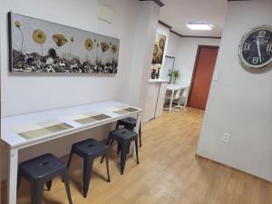 une table et des tabourets dans une pièce avec une horloge dans l'établissement Spacious Master Suite #5, à Séoul