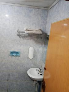 a bathroom with a white sink and a toilet at Vina Vira Hotel in Hagu