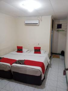 2 camas en una habitación con almohadas rojas en Vina Vira Hotel, en Hagu