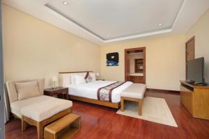 a hotel room with a bed and a television at Daisy Ocean Villa Da Nang in Da Nang