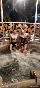 a group of women standing in a hot tub at Ricky's House in Baños