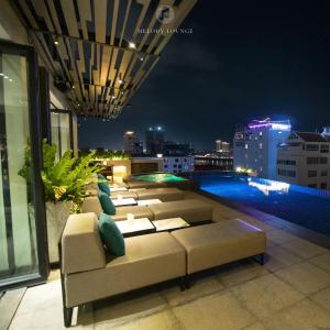 a couch sitting on top of a rooftop at night at Harmony Phnom Penh Hotel in Phnom Penh