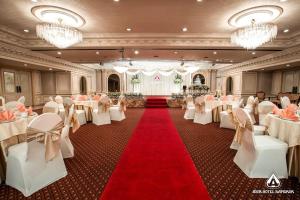 um salão de banquetes com mesas e cadeiras brancas e um tapete vermelho em Asia Hotel Bangkok em Bangkok