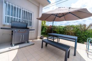 - une terrasse avec un barbecue, un banc et un parasol dans l'établissement private house noko, à Île Miyako