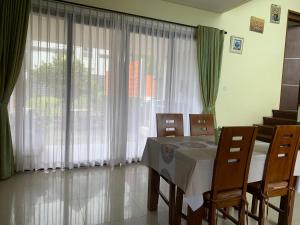a dining room with a table and chairs and a window at Villa Qfa Syariah in Lembang